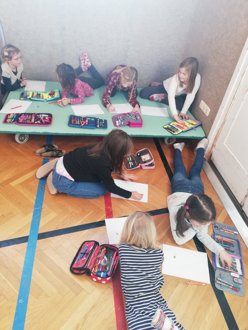 eine Gruppe von Mädchen, die auf dem Boden sitzen und ein Spiel spielen
