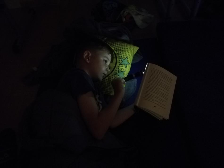 Eine Person, die sich hinlegt und ein Buch liest